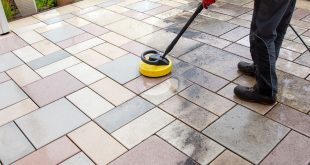 Cleaning stone slabs on patio with the high-pressure cleaner.